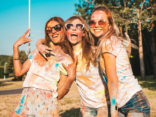 Three beautiful smiling girls posing at Holi party