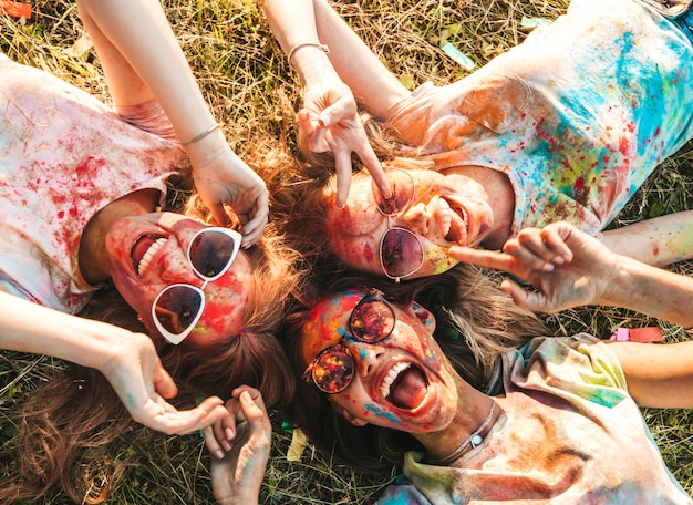 Three beautiful smiling girls posing at holi party