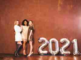 Free photo three beautiful women celebrating new year.happy gorgeous female in stylish