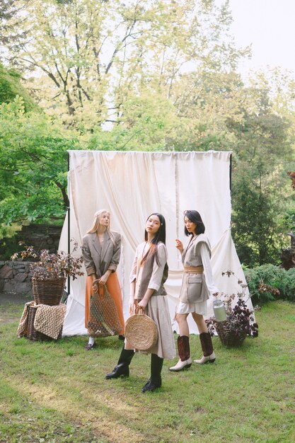 Three beautiful women standing and looking in garden .