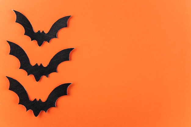 Free photo three black paper bats for halloween