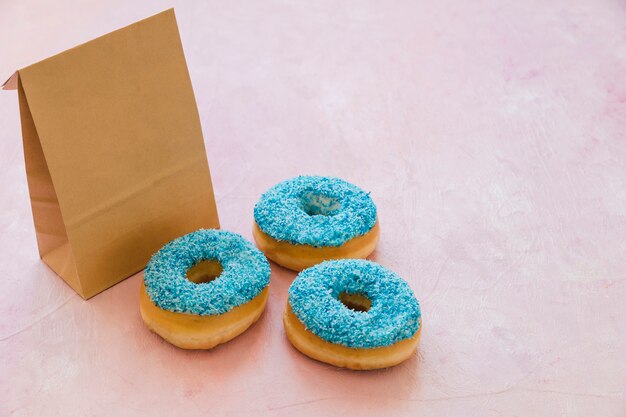 Three blue donuts with parcel on pink background