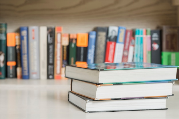 Free photo three books near bookshelf