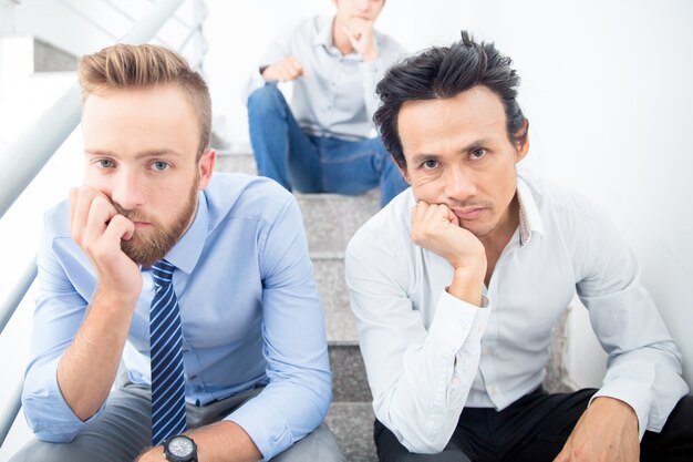 Three Bored Business Men Sitting on Stairs