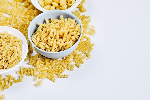 Three bowls of uncooked pastas o