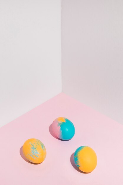 Three bright Easter eggs scattered on table