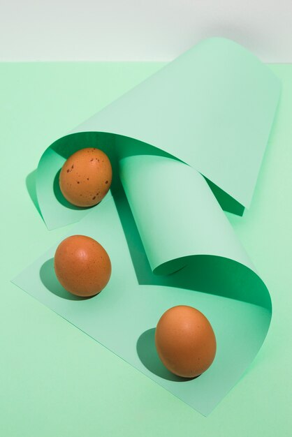 Three brown chicken eggs with green rolled paper 