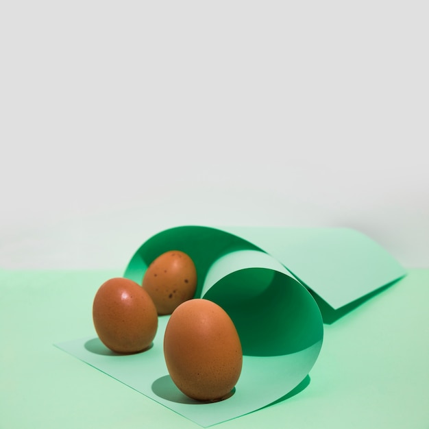 Three brown chicken eggs with rolled paper 