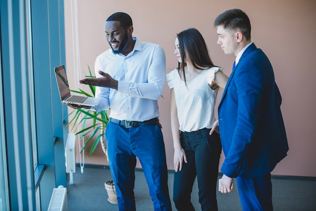 Three business people with laptop