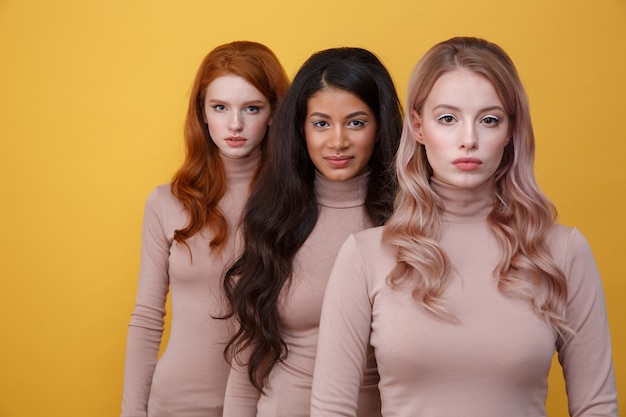 Three calm women standing in studi