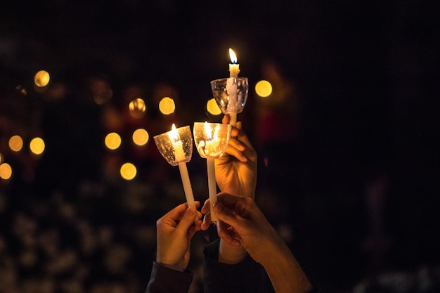 Three candles held in hands