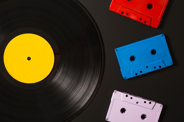 Three cassette tapes and vinyl record on black background