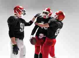 Free photo the three caucasian fitness men as american football players posing  as winners on white background and rejoicing