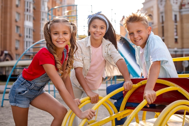 Free photo three cheerful friends playing in a playground