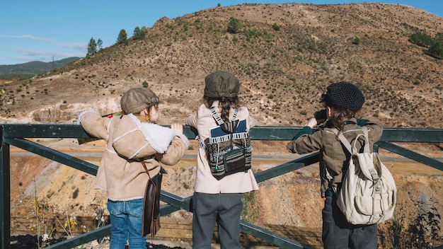 Three children looking at hill