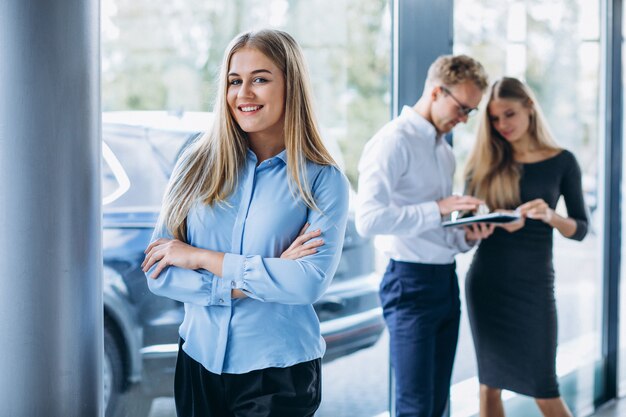 Three collegues working at a car showroom