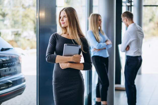 Three collegues working at a car showroom