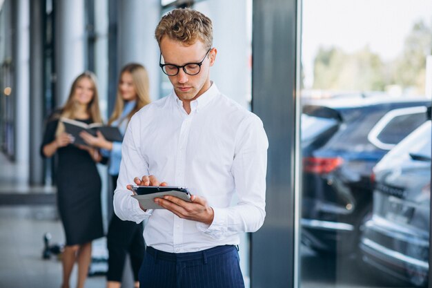 Three collegues working at a car showroom