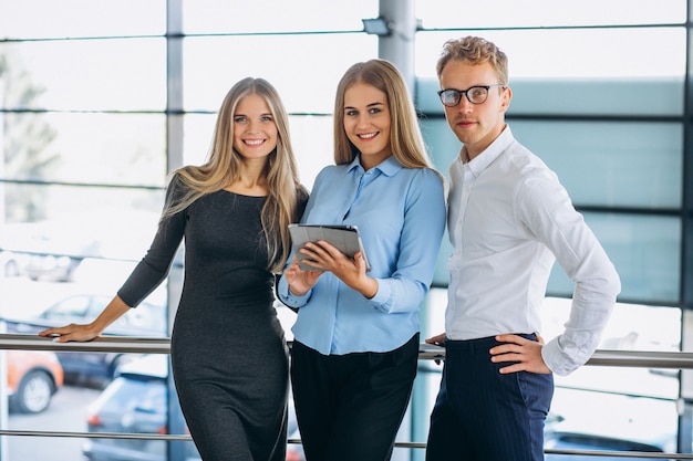 Three collegues working at a car showroom