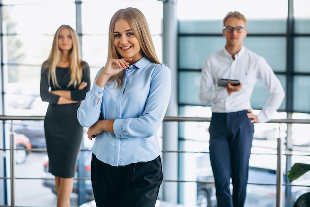 Three collegues working at a car showroom