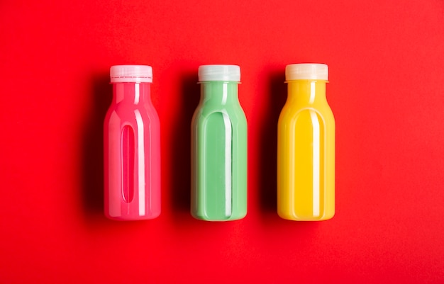 Three colorful smoothies on red background