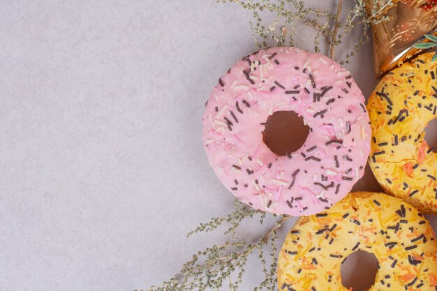 Three colorful sweet doughnuts on white surface 