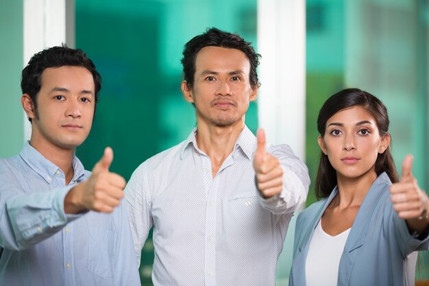 Three Confident Business People Showing Thumbs up