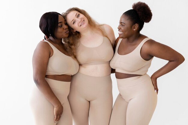 Three confident happy women posing while wearing a body shaper
