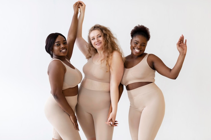 Free Photo three confident women posing together while wearing a body shaper