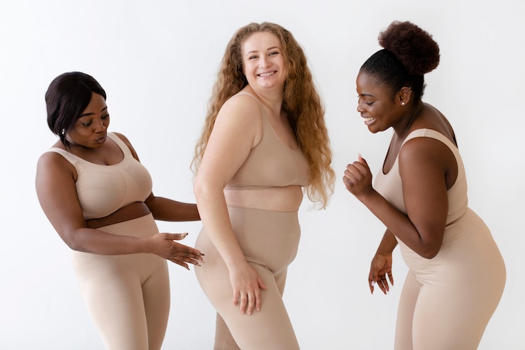 Free Photo three confident women posing together while wearing a body shaper