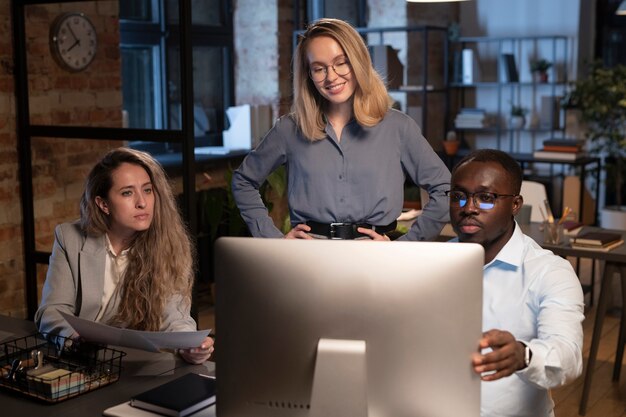 Three coworkers looking the monitor