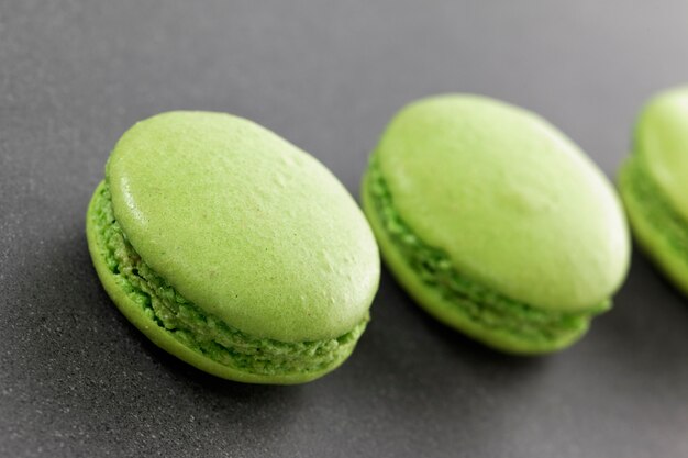 Three delicious green macaroons in kitchen