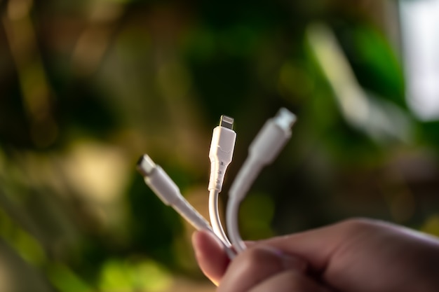 Three different connectors for charging a mobile phone on a blurred background