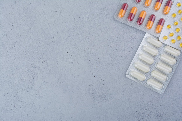 Three different packs of drugs on marble surface.