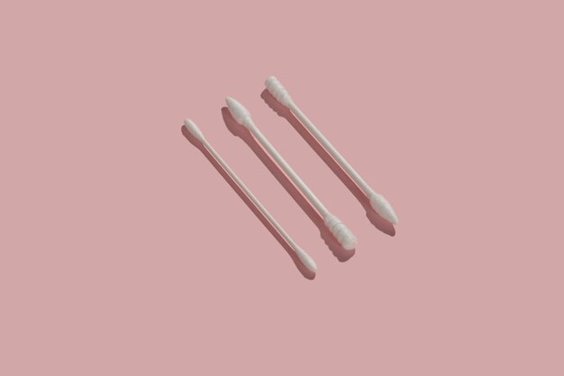 Three different shaped cotton swab on pink background
