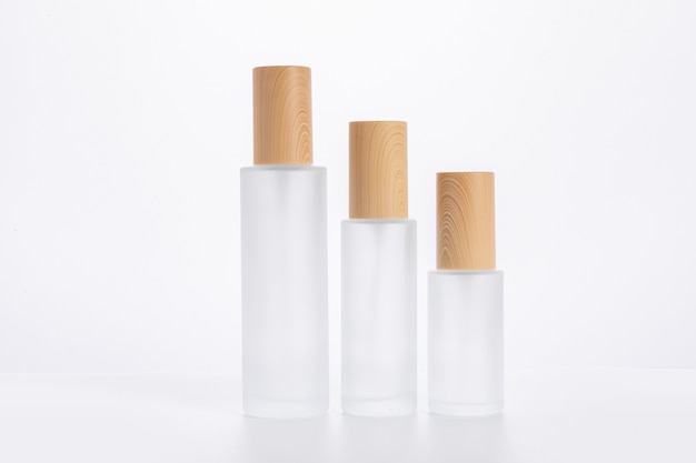 Three different sized skincare bottles isolated on a white surface