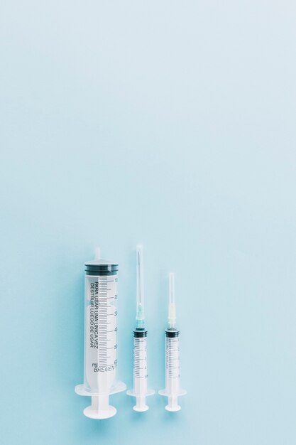 Three different type of transparent syringe against blue background