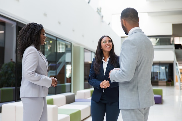 Free photo three diverse business partners meeting in office hall