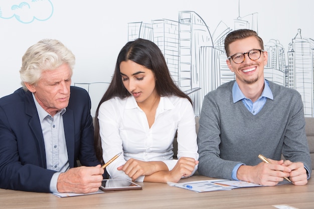 Three Diverse Positive Colleagues Working in Cafe