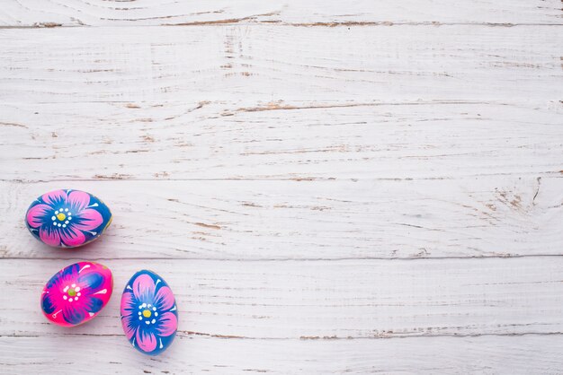 Three easter eggs on wooden surface