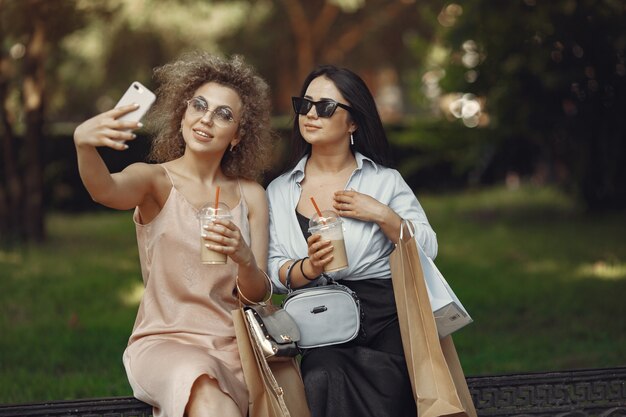 Three elegant women with shopping bags in a city