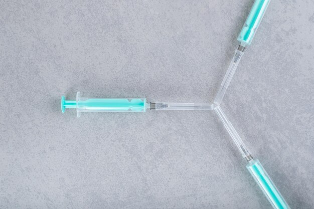 Three empty syringes on gray background. 