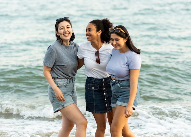 Tre amiche che hanno divertimento sulla spiaggia