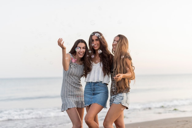 Free photo three female friends at the shoreline