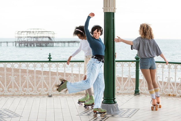 야외에서 롤러 스케이트를 탄 세 명의 여자 친구