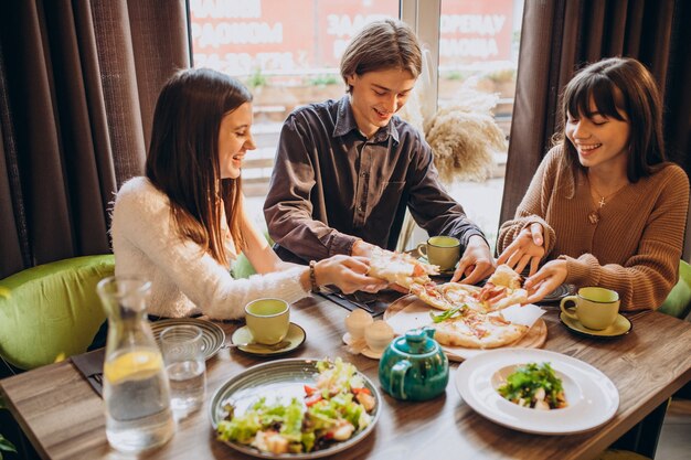 カフェで一緒にピザを食べる3つのfirends