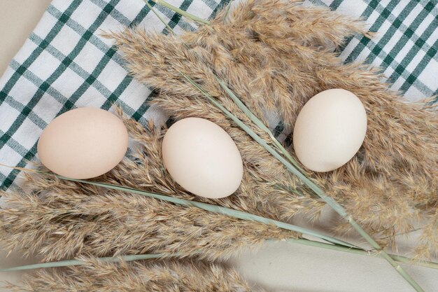 テーブルクロスに新鮮な鶏の白い卵3個。