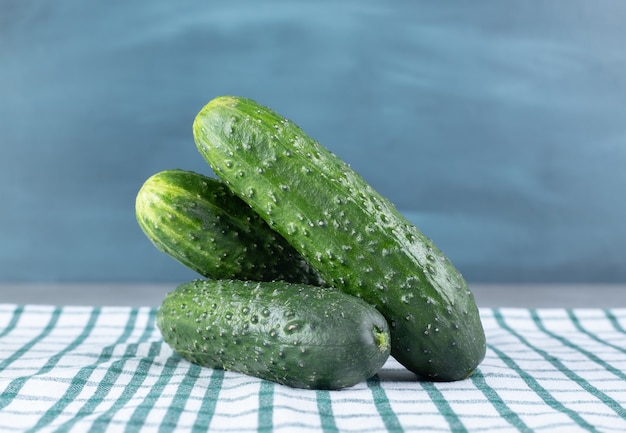 Free photo three fresh cucumbers isolated on a tablecloth. high quality photo