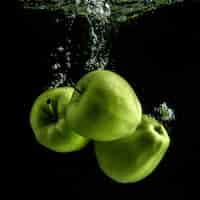 Бесплатное фото Три свежие зеленые яблоки в воде