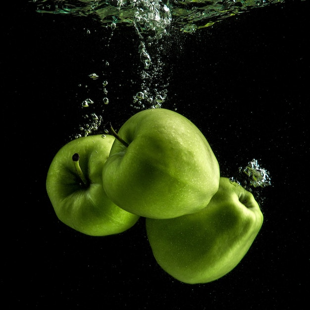 Three fresh green apples in the water